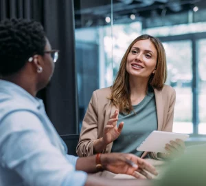 a pair of women talking in an office