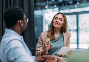 a pair of women talking in an office