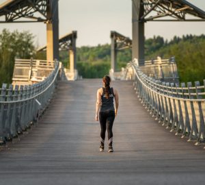 a woman walking along a bridge in edmonton