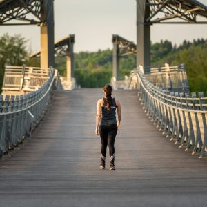 a woman walking along a bridge in edmonton