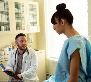 a patient in a gown talking to a doctor