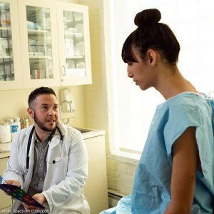 a patient in a gown talking to a doctor