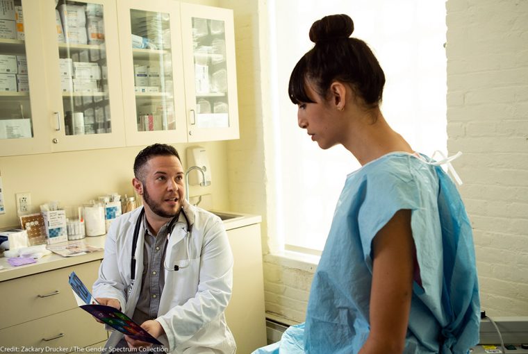 a patient in a gown talking to a doctor