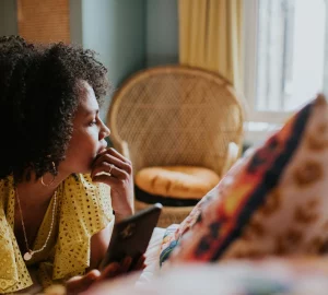 a woman on a device looking out a window