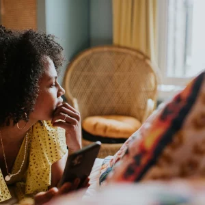 a woman on a device looking out a window