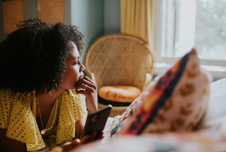 a woman on a device looking out a window