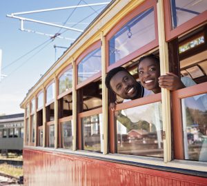a couple lookin gout the window of a train car
