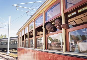 a couple lookin gout the window of a train car