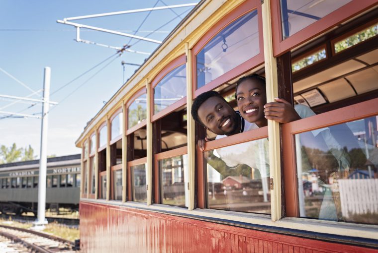 a couple lookin gout the window of a train car