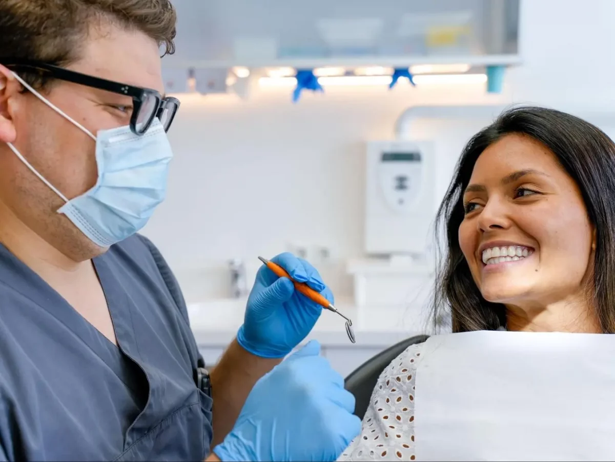 a woman getting her teeth checked by a dentist