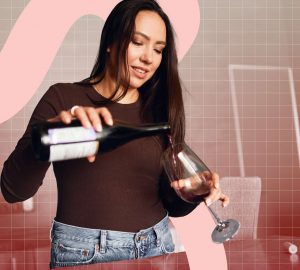 a woman pouring a glass of red wine