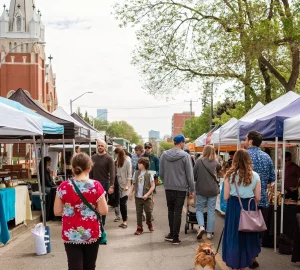 a crowd walking through the farmers market
