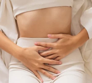 a woman with her hands on her abdomen