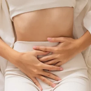 a woman with her hands on her abdomen