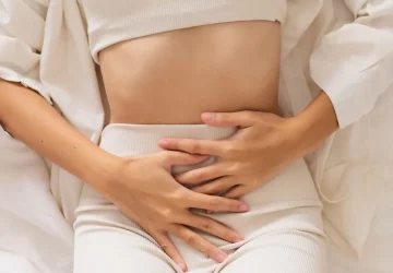 a woman with her hands on her abdomen