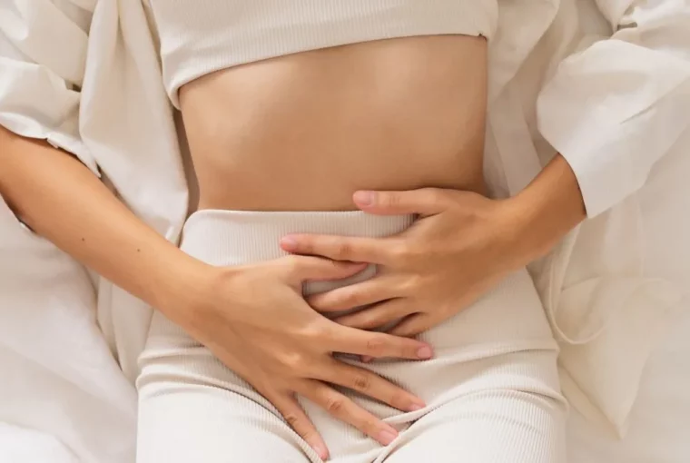 a woman with her hands on her abdomen