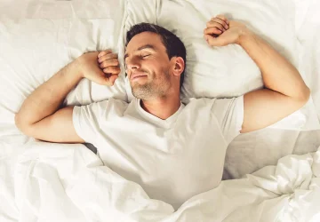 a man stretching in bed
