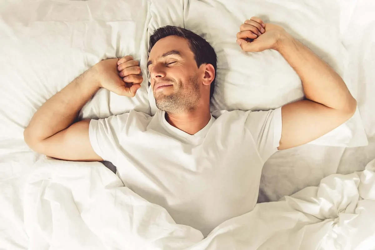 a man stretching in bed