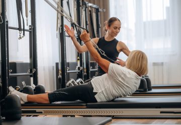 Active training. Female trainer is helping woman to exercise.